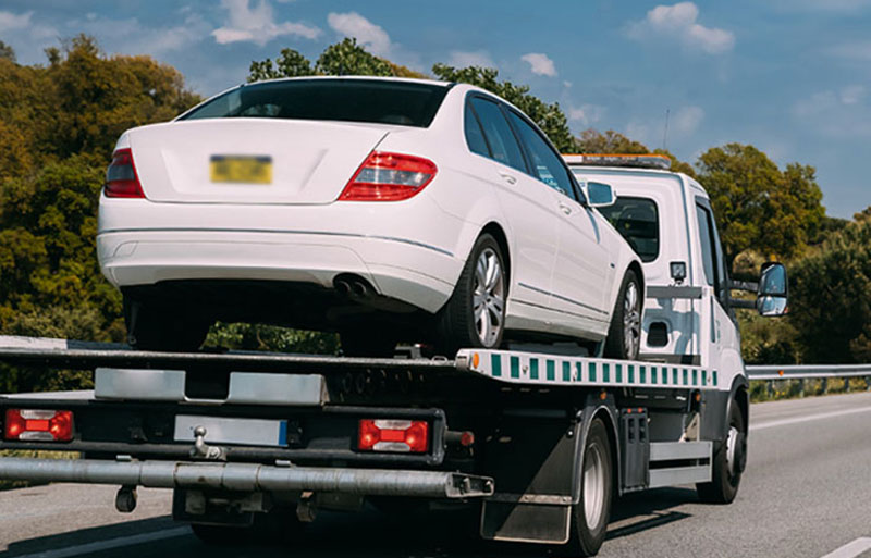 tow truck carrying broken down car