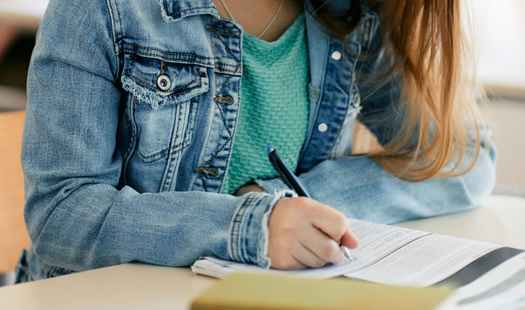young woman taking notes during lecture