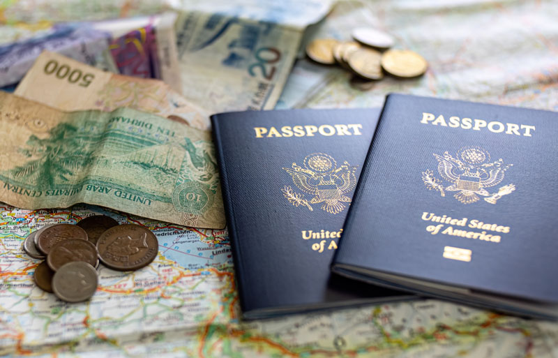 passports and foreign currency on top of world map