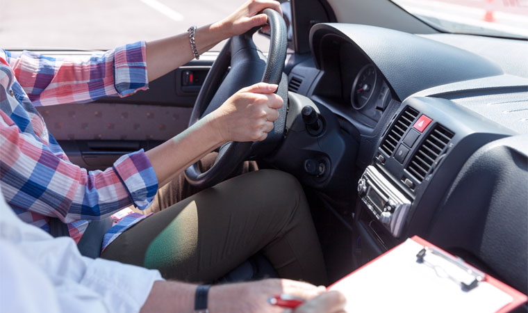 driving instructor sitting in passenger seat with clipboard