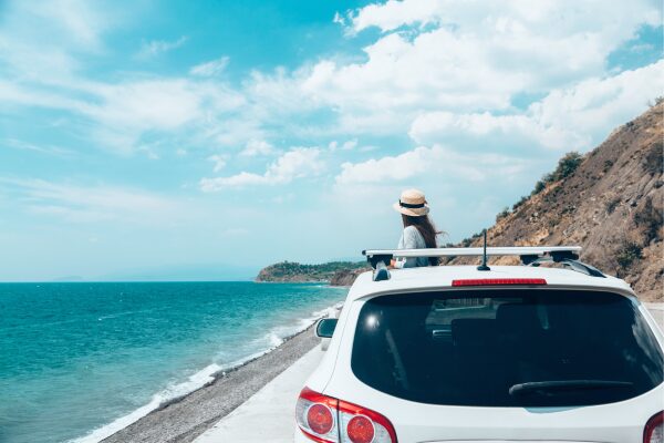 car on road alongside ocean