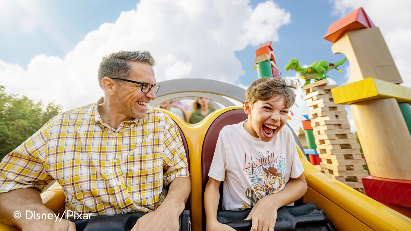 dad and son riding slinky dog dash in toy story land